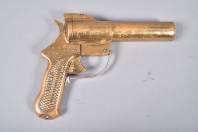 a gold gun that is sitting on a white table