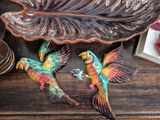 two colorful birds that are sitting on a table
