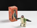 une petite figurine de pingouin posée à côté d'une boîte d'allumettes