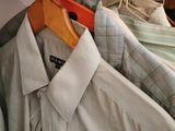many shirts hanging on a rack in a closet
