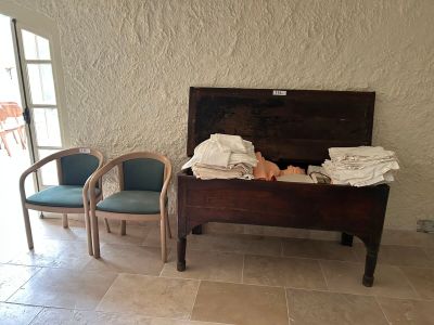 un bébé allongé dans un lit, dans une pièce où se trouvent deux chaises