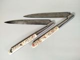 three knives that are laying next to each other on a table