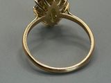 an image of a gold ring with a green stone in the center