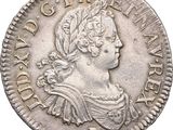 a silver coin with a woman ' s head and a crown on it