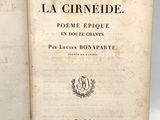 un livre ouvert posé sur une table, à côté d'un autre livre