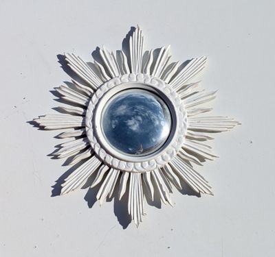 une image représentant un soleil rayonnant blanc avec un ciel bleu au centre