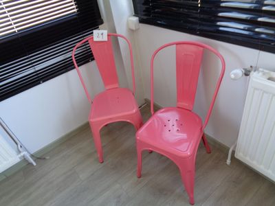 deux chaises roses posées près d'un radiateur dans une pièce