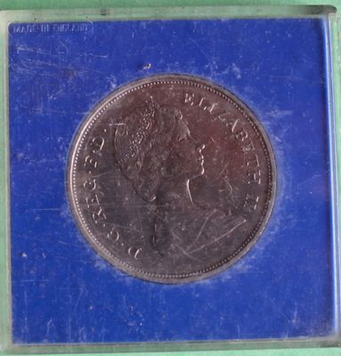 a close up of a coin in a blue box on a green surface