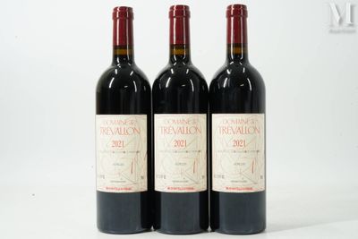 trois bouteilles de vin rouge posées sur une table blanche