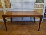 a wooden table with a glass top on a hard wood floor