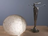 a white ball and a silver sculpture on a table