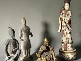 trois figurines représentant des hommes et des femmes asiatiques sont disposées sur une surface grise