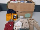 une boîte en carton sur laquelle sont posés des vêtements et une veste
