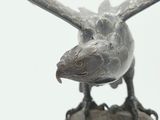 a statue of a bird on a rock with its wings spread