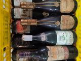 plusieurs bouteilles de vin dans un panier jaune posé sur la table