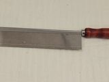 a close up of a knife with a wooden handle on a table