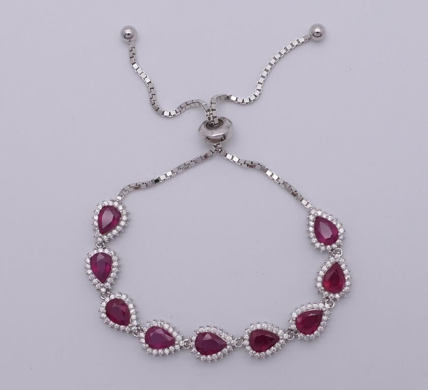 Bracelet lasso en argent, serti de rubis taille poire dans un entourage de pierres blanches. PB:13 gr.