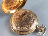 a gold pocket watch sitting on a blue surface