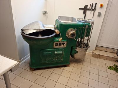 une machine verte posée dans une cuisine, à côté d'une poubelle