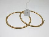 une paire de boucles d'oreilles en or sur fond blanc