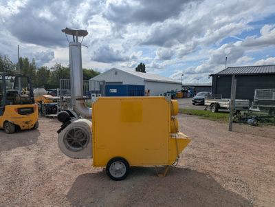 une petite machine jaune garée sur la terre battue