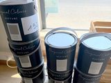 trois seaux de peinture posés sur une caisse en bois
