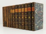 plusieurs vieux livres sont alignés sur une surface blanche
