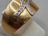 a close up of a gold ring with a diamond cross on it