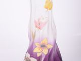 un vase en verre orné de fleurs peintes sur fond blanc