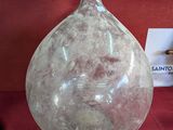 un grand vase en verre posé sur un tissu rouge
