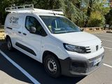 a white van parked in a parking lot with trees in the background