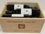 trois bouteilles de vin dans un coffret en bois sur une table