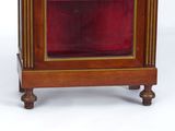a small wooden clock with a red glass case
