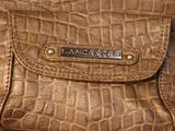 brown leather purse with a nameplate on it sitting on a table