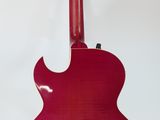 a close up of a red guitar on a stand against a white background