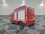 a red fire truck parked in a room with a checkered floor