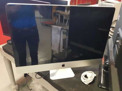 a man standing in front of a computer monitor