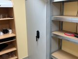 a cupboard and shelves in a room with yellow walls