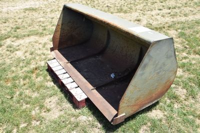 a large metal bucket sitting in the middle of a field