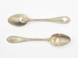 two spoons that are sitting next to each other on a table