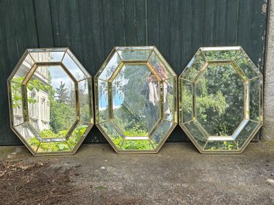 three mirrors sitting on top of a sidewalk next to a building