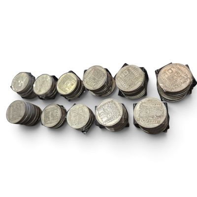 un tas de pièces empilées les unes sur les autres sur une surface blanche
