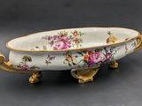 a white bowl with flowers on it sitting on a table