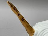 a white and gold figurine with a gold horn on it