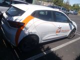 a white car with an orange stripe parked in a parking lot
