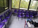 de nombreuses chaises violettes dans une pièce dotée d'une grande fenêtre