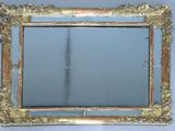 un miroir avec un cadre doré accroché au mur