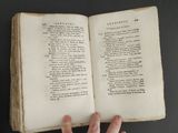 a person holding an open book on a table
