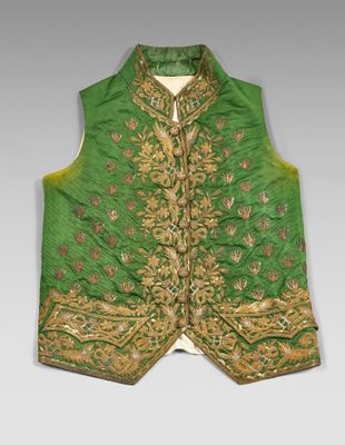 a close up of a green vest with gold embroidery on it