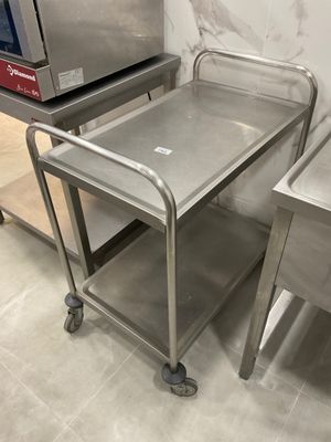 two stainless steel tables with a microwave on top of them